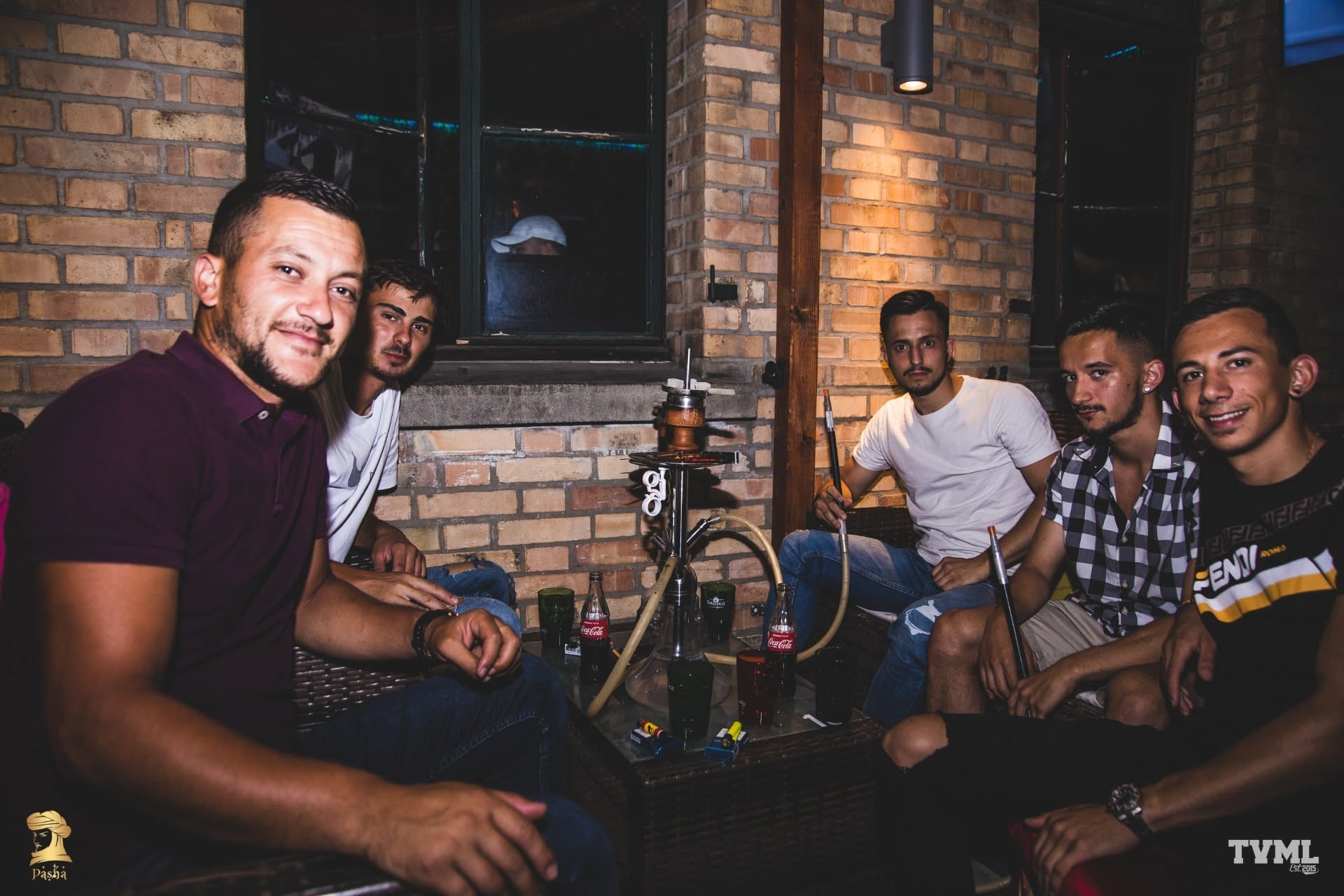 Gäste sitzen gemeinsam an einem Shisha-Tisch